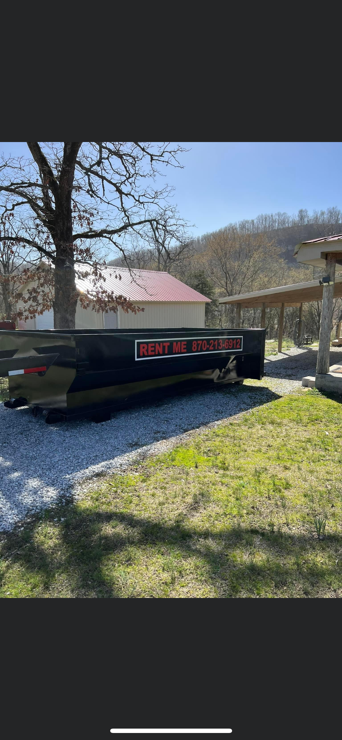 Two environmentally friendly dumpster bins, made from recycled materials, sit before a closed garage door.